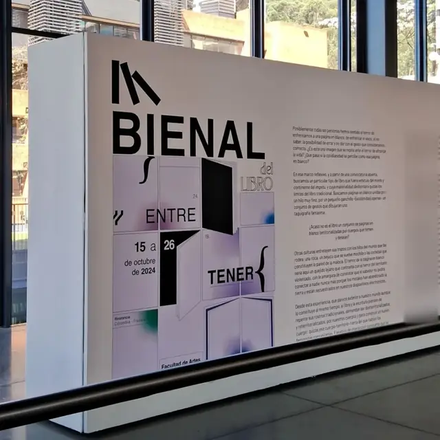 An exhibition wall reading Bienal del Libro, Entre-Tener, 15 a 26 de octubre de 2024, Facultad de Artes, next to a column of curatorial text.