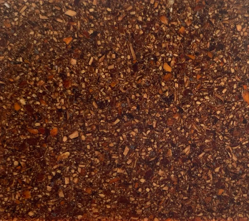 Macro close-up of Nutty: dark crushed organic particles locked in resin.